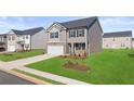 Charming two-story home with a two-car garage, manicured lawn, and lovely landscaping at 169 Aster Avenue, Locust Grove, GA 30248