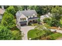 Gorgeous aerial view of a two-story home featuring a brick exterior, dark roof, and a spacious driveway at 819 Loridans Dr, Atlanta, GA 30342