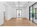 Bright dining room with hardwood floors, modern lighting, and a stunning black metal frame front door at 819 Loridans Dr, Atlanta, GA 30342