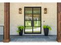 Inviting front entrance featuring a black metal door, decorative lights, and manicured plants at 819 Loridans Dr, Atlanta, GA 30342