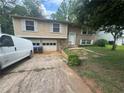 Exterior of a split-level home featuring a brick and vinyl facade, driveway, and attached garage at , Roswell, GA 30076