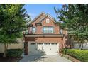 Attractive brick home featuring a two-car garage and lush, green landscaping at 49 Braemore Mill Dr, Lawrenceville, GA 30044