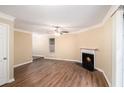 Bright living room featuring a cozy fireplace, modern ceiling fan and wood flooring at 6403 Charter Way, Lithonia, GA 30058