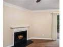 Bright living room featuring a cozy fireplace, modern ceiling fan and wood flooring at 6403 Charter Way, Lithonia, GA 30058