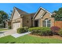 Charming home featuring a well-manicured lawn and garden, and a two-car garage with barn-style doors at 3802 Abbott Ln # 14, Powder Springs, GA 30127