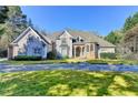 Inviting home boasts manicured lawn and long driveway for convenient parking at 3871 River Mansion Dr, Peachtree Corners, GA 30096
