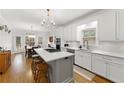 Bright kitchen featuring white cabinets, a marble countertop island with seating, and stainless steel appliances at 4250 Green Ridge Ne Dr, Marietta, GA 30062