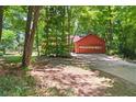 A detached garage with a roll-up door and concrete driveway in a wooded setting at 2945 Cardinal Lake Cir, Duluth, GA 30096