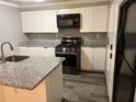 The kitchen features white cabinetry, granite countertops, and modern stainless steel appliances at 6353 Wedgeview Ct, Tucker, GA 30084