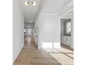 Bright hallway with hardwood floors, white trim, and natural light streaming through the window at 4190 Hosch Reserve Dr, Buford, GA 30519