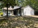 View of the home featuring white siding, black trim, decorative yard accents, and a well-maintained lawn at 1771 Kristi Dr, Lawrenceville, GA 30043