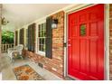 Inviting front porch featuring a bright red door, brick facade, and comfortable seating at 1831 Galilee Ct, Tucker, GA 30084