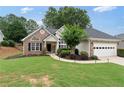 Welcoming curb appeal with manicured lawn, brick and siding facade, and an attached garage, creating an inviting home exterior at 3549 Daventry Nw Ln, Kennesaw, GA 30144