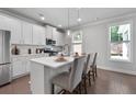 Bright kitchen with white cabinetry, stainless appliances, breakfast bar, and natural light from the adjacent window at 197 Stafford Ln, Villa Rica, GA 30180