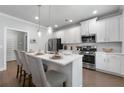 Modern kitchen with white cabinets, stainless steel appliances, quartz countertops, and a breakfast bar at 197 Stafford Ln, Villa Rica, GA 30180