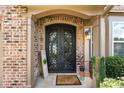 Elegant front entrance featuring a wrought iron double door and manicured landscaping, creating a welcoming curb appeal at 1146 Simonton Peak Way, Lawrenceville, GA 30045