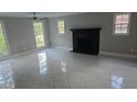 Bright living room with a fireplace, tile floors, gray walls, and abundant natural light at 1947 Kensington High Sw St, Lilburn, GA 30047