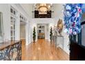 Elegant two-story foyer featuring gleaming hardwood floors, wainscoting, and a view of the living spaces at 5995 Ettington Dr, Suwanee, GA 30024