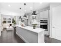 Open-concept kitchen features a large center island, stainless steel appliances, modern pendant lighting, and seamless flow to living area at 3933 Danube Ln # 224, Atlanta, GA 30339