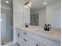 Bathroom featuring double vanity sinks, a large mirror, and a glass enclosed shower at 1919 Deco Dr, Kennesaw, GA 30144