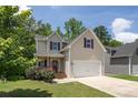 Charming two-story home featuring a covered porch, two-car garage, and tasteful neutral siding at 108 Spring View Br, Dallas, GA 30157