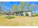 Single-story home with covered porch, open garage, and a well-maintained lawn and landscaping at 5774 Harbor Dr, Buford, GA 30518