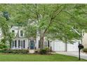 Attractive two-story home featuring a well-manicured lawn, mature trees, and a convenient two-car garage at 2429 Brookgreen Nw Commons, Kennesaw, GA 30144
