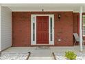 Welcoming front door with sidelights and brick surround at 3601 Stephens Creek Pl, Loganville, GA 30052