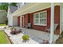 Inviting front porch with chairs, decorative rock landscaping, and brick facade at 3601 Stephens Creek Pl, Loganville, GA 30052