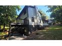Exterior view of the home's deck with stairs to the backyard and a black painted foundation at 409 Arbor Ridge Dr, Stone Mountain, GA 30087