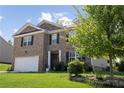 Inviting two-story house with brick facade, attached garage, and lush green lawn at 450 Noblewood Dr, Mcdonough, GA 30252