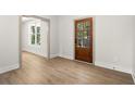 Bright entry room with a wooden door, large window and light wood floors at 5125 Hyde Trl, Cumming, GA 30040