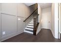 Hallway features elegant dark hardwood floors, a staircase, and wainscotting on the left for added architectural detail at 280 Briscoe Way # 38, Alpharetta, GA 30009