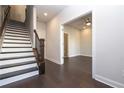 Hallway features elegant hardwood floors, bright staircase, and doorway that reveals the bathroom and bedroom beyond at 280 Briscoe Way # 38, Alpharetta, GA 30009