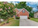 Beautiful two-story brick home showcasing manicured landscaping and a white two-car garage door at 1446 Chadwick Ridge Ct, Lawrenceville, GA 30043