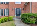 Close-up of the front door framed by manicured bushes and classic brick architecture at 1446 Chadwick Ridge Ct, Lawrenceville, GA 30043