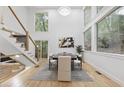 Bright dining room with hardwood floors, modern lighting, and large windows overlooking a wooded area at 1153 Dawn View Ne Ln, Atlanta, GA 30327