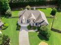 A beautiful aerial view of this landscaped property with a manicured lawn and mature trees at 1539 School House Run, Dacula, GA 30019