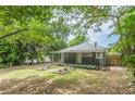 Spacious backyard with mature trees, flower beds, and a covered patio area for outdoor entertaining at 523 North Ave, Atlanta, GA 30354