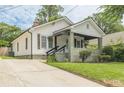 This inviting home has a well-maintained lawn and a covered front porch with decorative landscaping at 523 North Ave, Atlanta, GA 30354