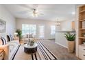 Bright living room boasts neutral walls, plush carpeting, a ceiling fan, and access to the dining area at 1362 Rogers Trce, Lithonia, GA 30058