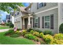 Landscaped front yard of a two-story home features lush greenery and colorful flowers at 1530 Parkside Village Dr, Cumming, GA 30040