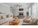 Bright living room features a cozy fireplace, comfortable seating, and large windows at 3604 Cameron Hills Pl, Ellenwood, GA 30294