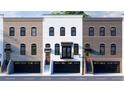 Elegant townhomes with varied brickwork, private garages, individual entrances, and black framed windows at 345 Sugarview Rd, Sugar Hill, GA 30518