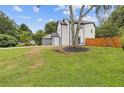 Spacious backyard featuring lush green grass, mature trees, and a wood fence at 1164 Red Oak Cv, Tucker, GA 30084