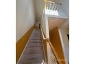 Well-lit staircase with carpeted steps and wooden railings leading to the upper level at 3324 Whitmore Ct, Acworth, GA 30101