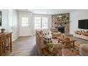 Cozy living room featuring a stone fireplace, hardwood floors, and natural light from the windows at 914 Hemingway Rd, Stone Mountain, GA 30088