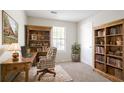 Functional home office with wooden desk, shelving, and a comfortable chair near a window at 914 Hemingway Rd, Stone Mountain, GA 30088