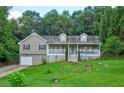 Beautiful two-story home featuring a welcoming front porch and a lush green lawn with mature trees at 1137 Eagles Nest Cir, Carrollton, GA 30116