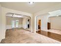 Open living room with neutral carpet and arched doorways to dining and entry at 3677 Trillium Forest Dr, Snellville, GA 30039